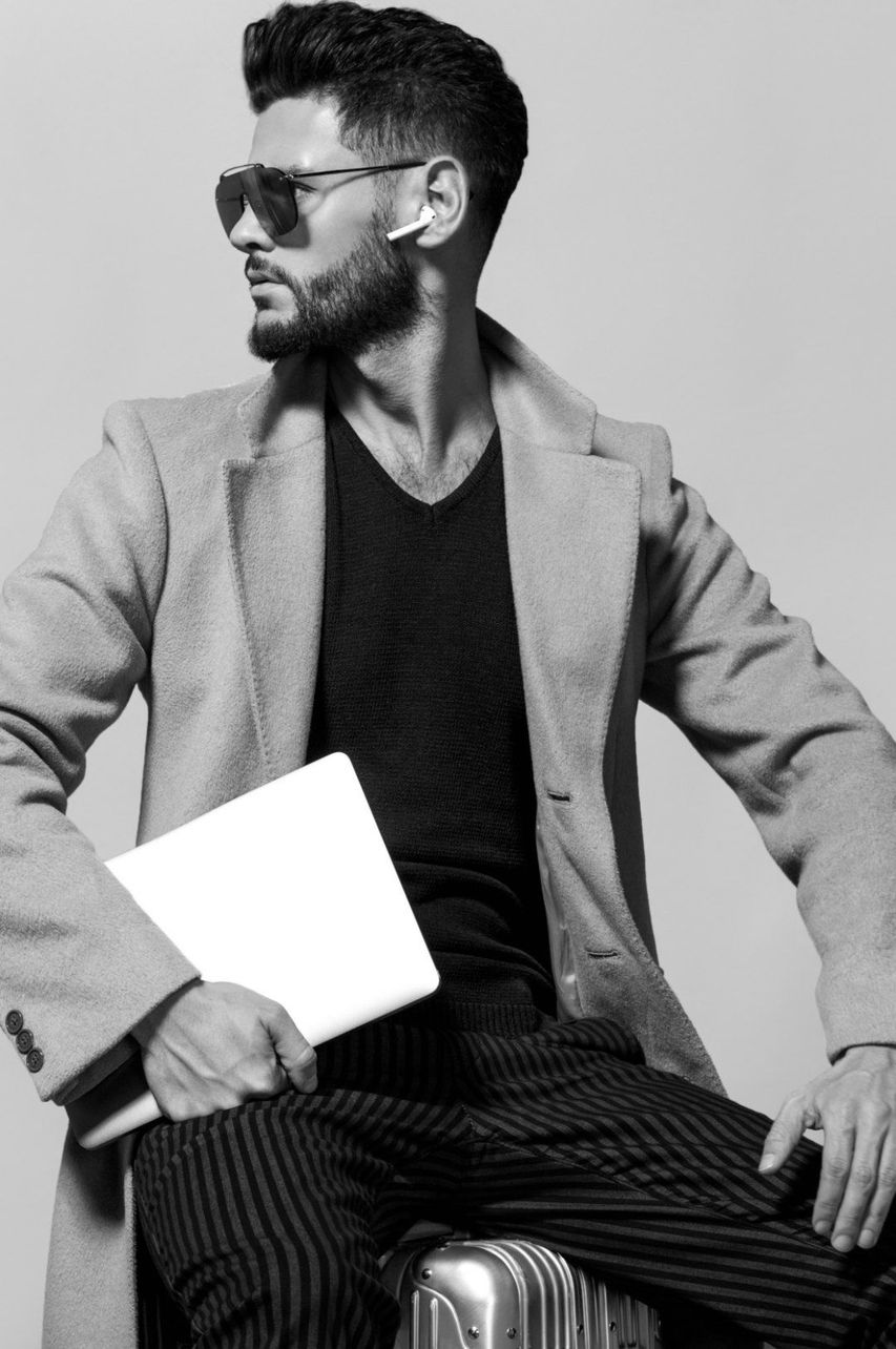 Hombre moderno con carpeta y gafas de sol sentado